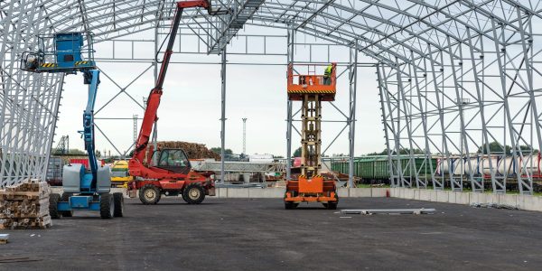 Lift with platform work in warehouse hangar construction field.